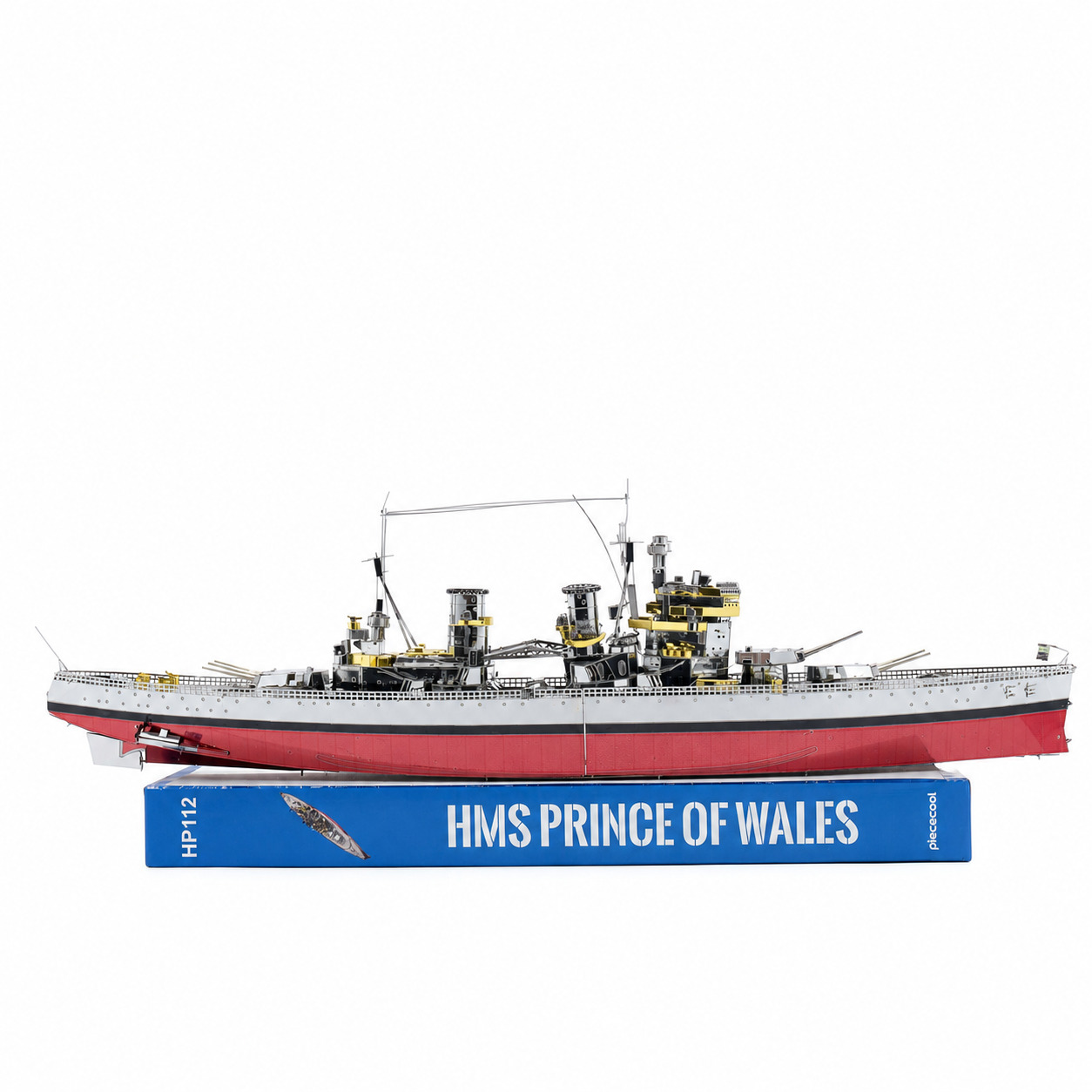 Detailed model of the HMS Prince of Wales battleship on a blue book