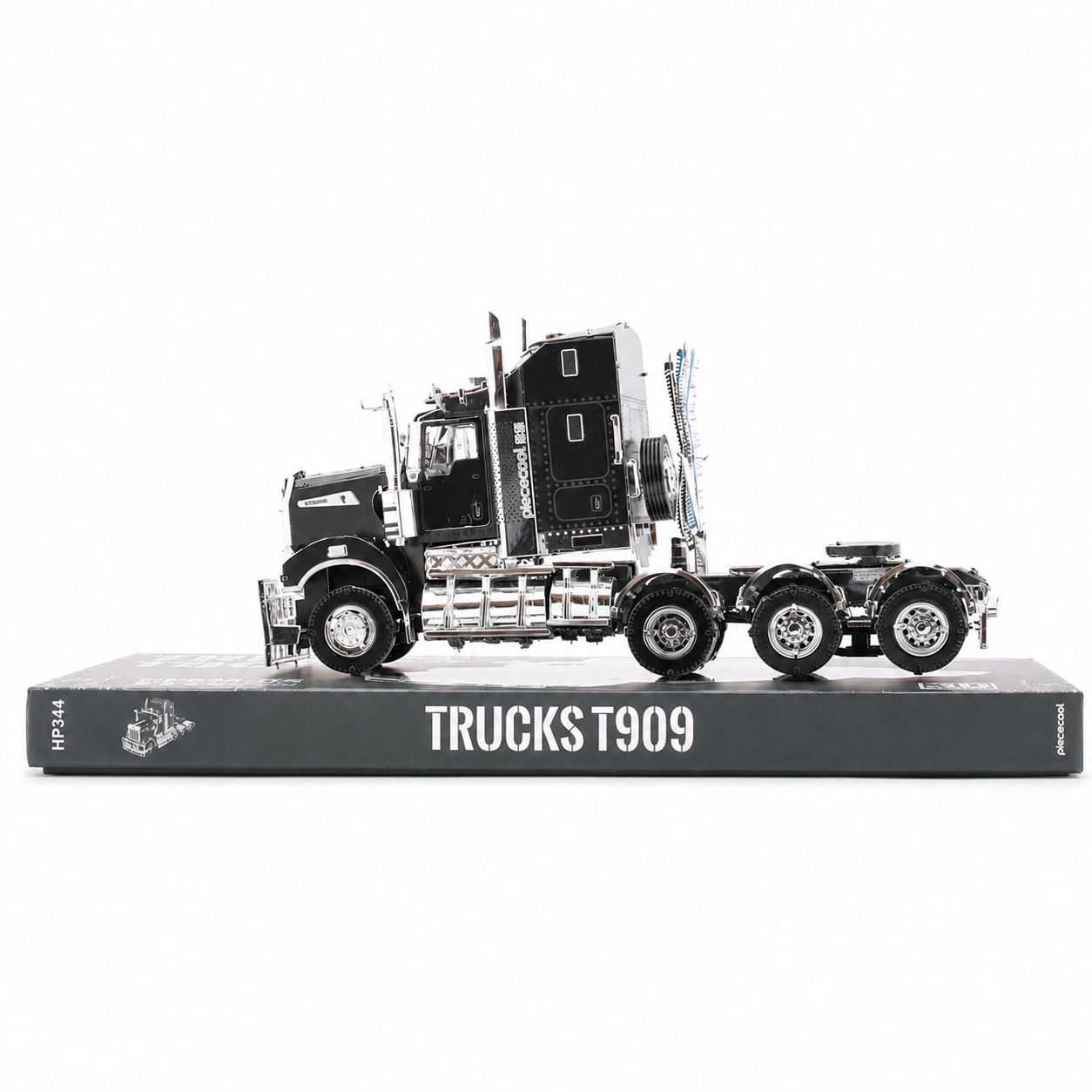 Model of a black and chrome truck displayed on a book titled 'Trucks T909'.