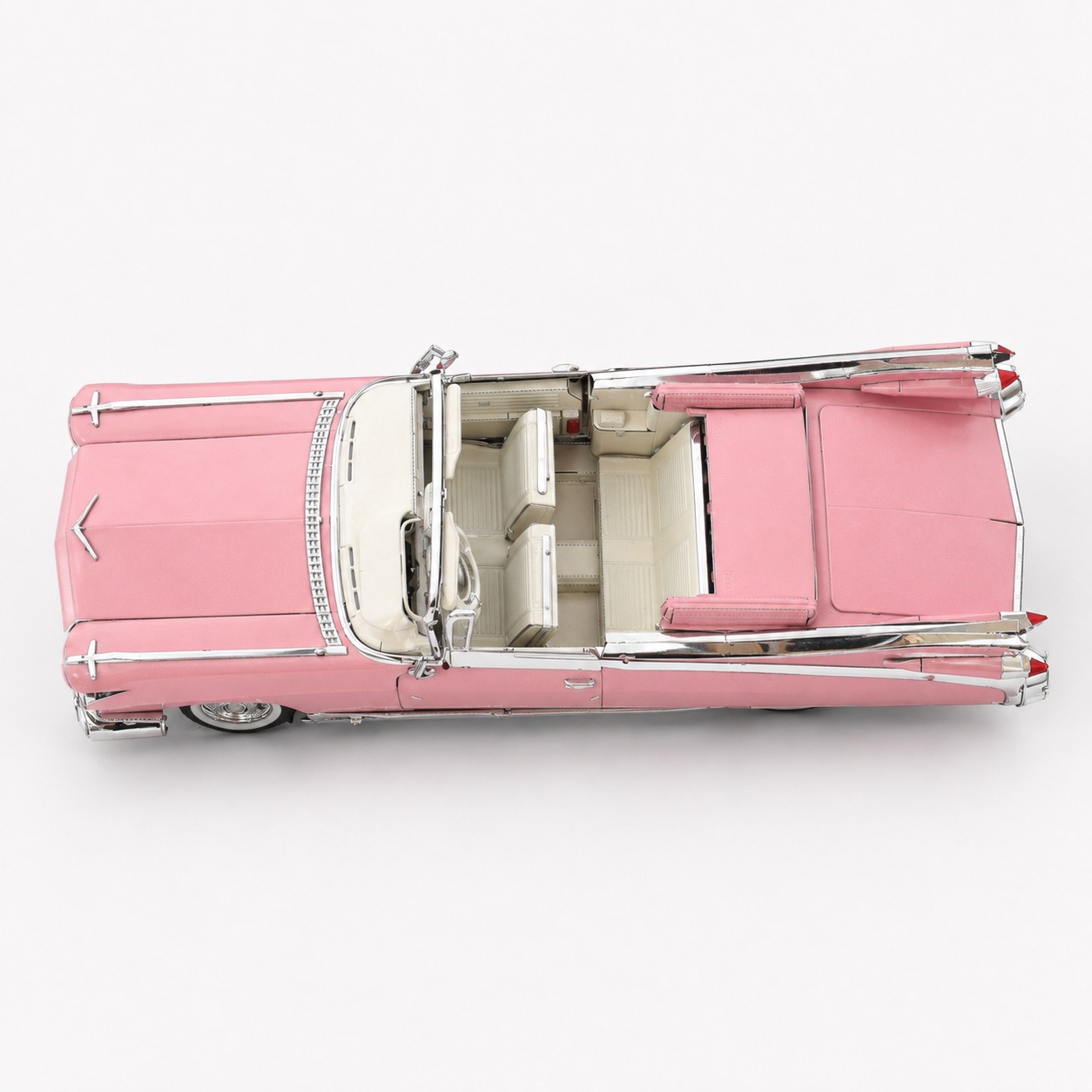 Top view of a vintage pink convertible car with a cream interior.