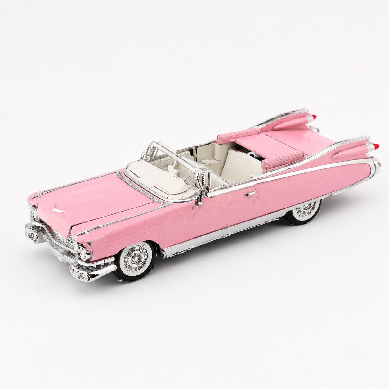 A pink vintage convertible car model with shiny details.